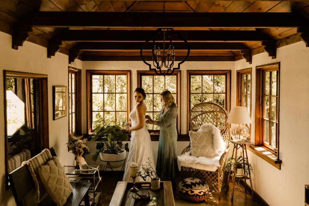bride getting into dress photos documentary style airbnb wedding photographer