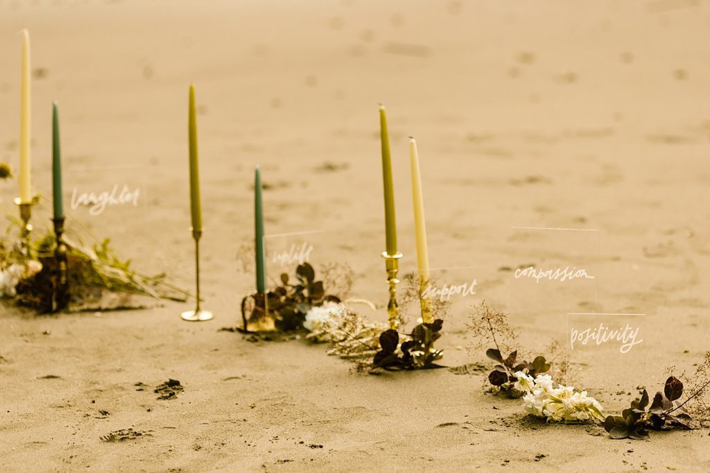 Candles and floral ceremony set up on the beach elopement