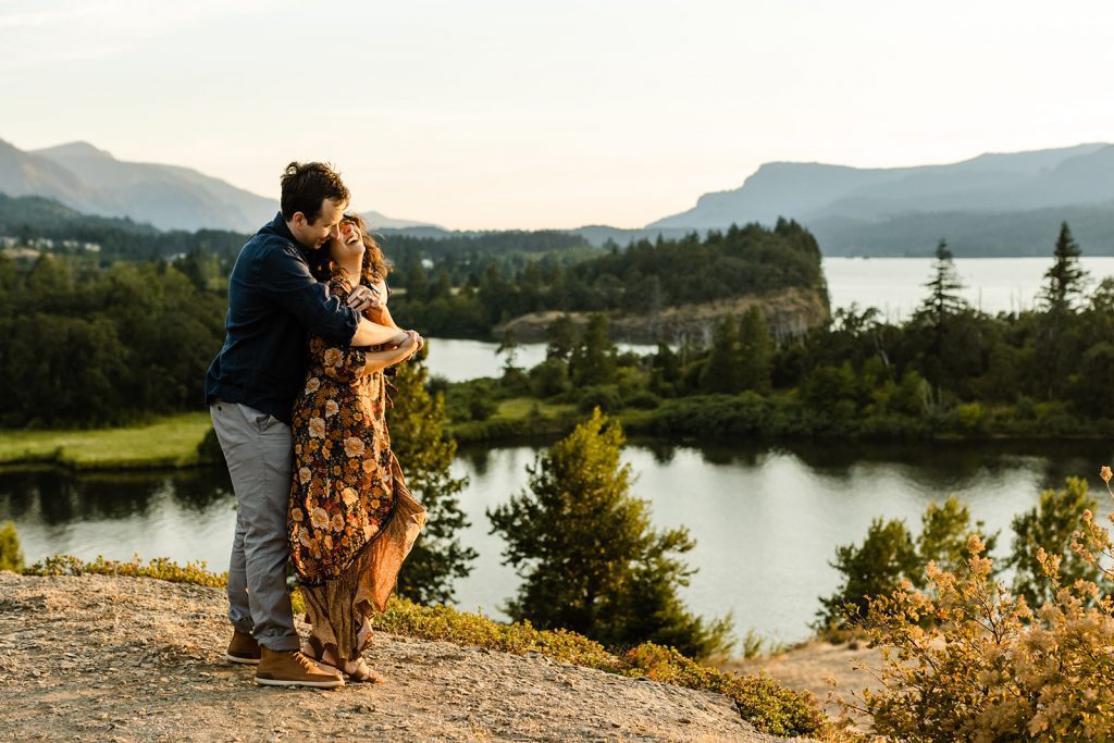 What to wear for my engagement session Anthropologie floral dress at Columbia Gorge, couple wrapped up in a hug overlooking the sunset