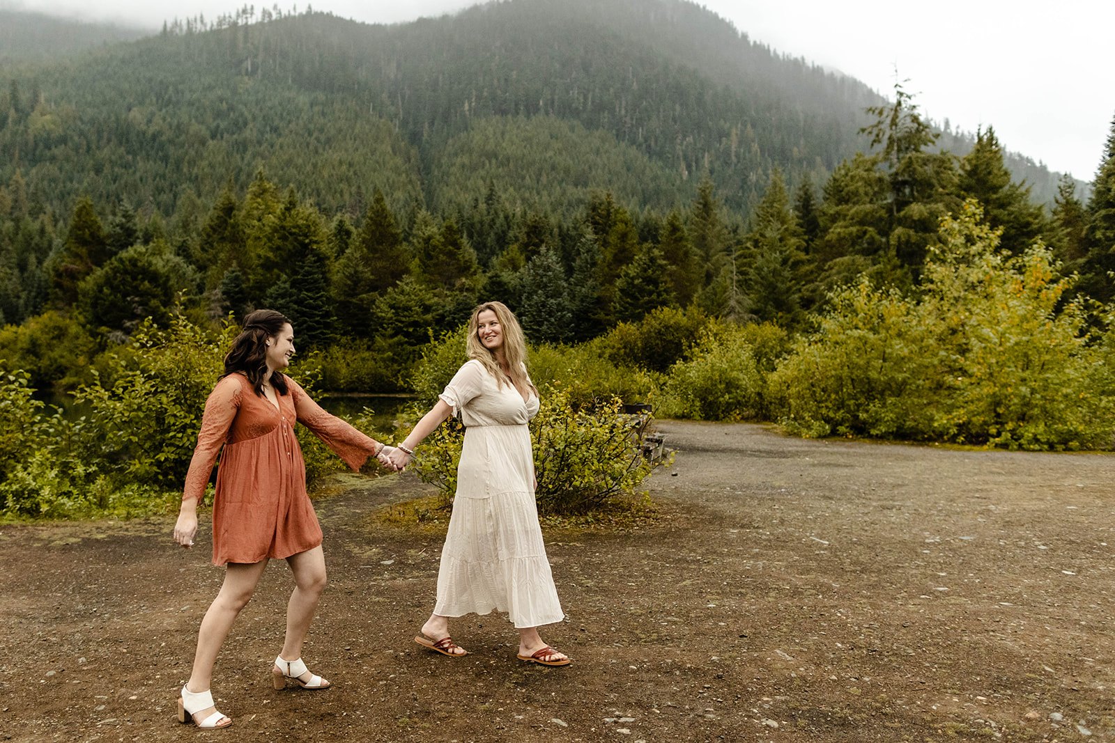 couple holds hands and walks across the frame from left to right at their fall engagement photos 