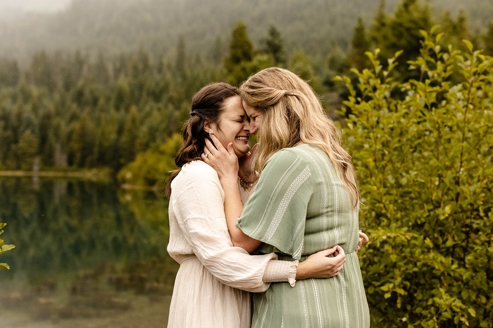 couple stands forehead to forehead, laughing and hugging, and their fall engagement photos session