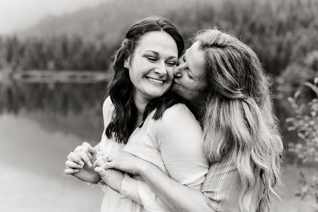 partner leaves a kiss on her fiancee's cheek 