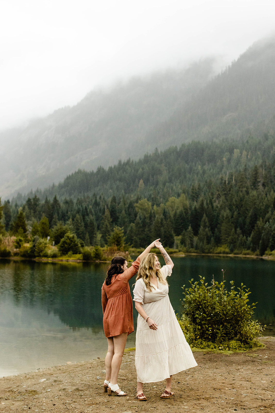 couple twirls each other, laughing, at their fall engagement photos session
