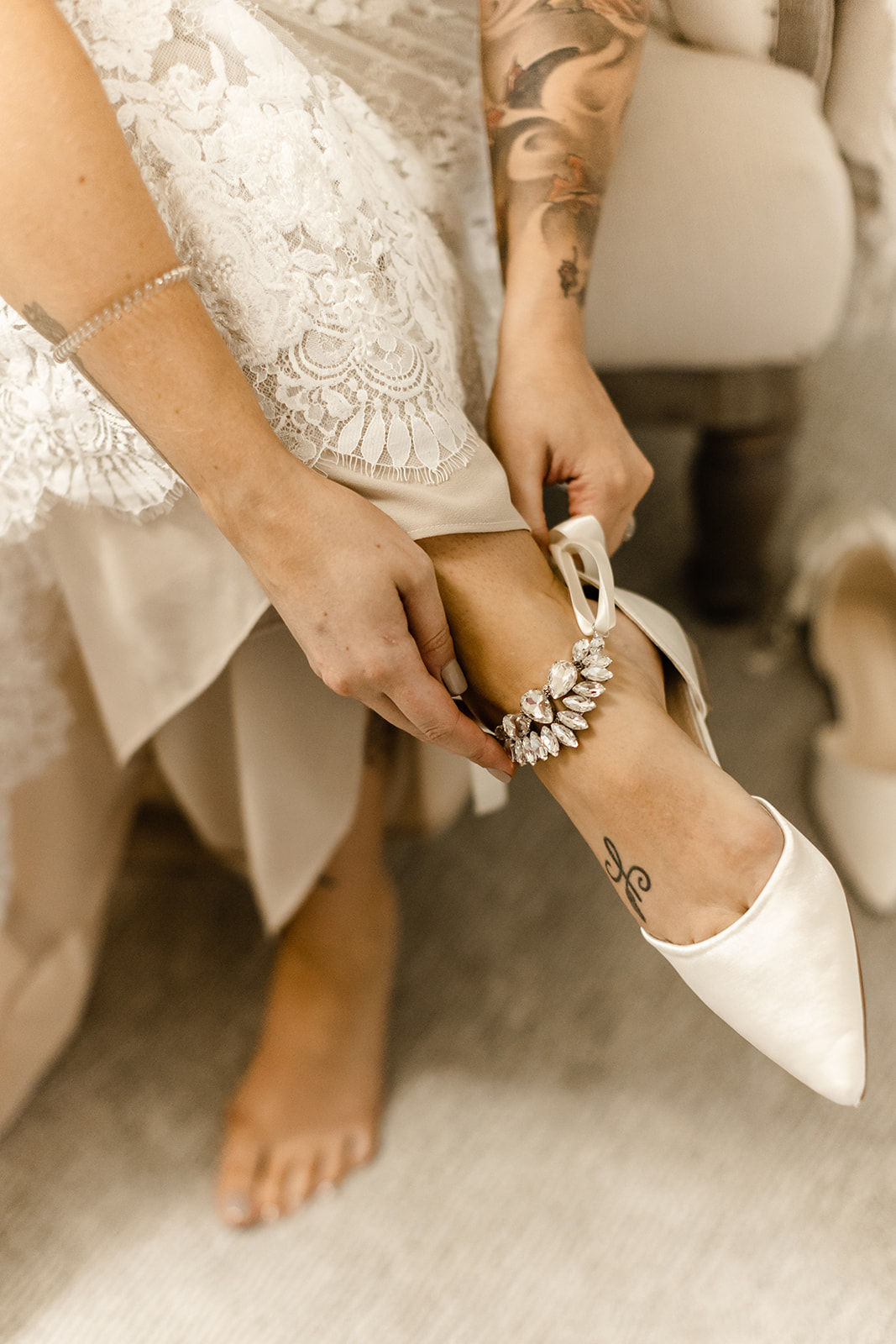 Bride fastens her shoes before her wedding. 