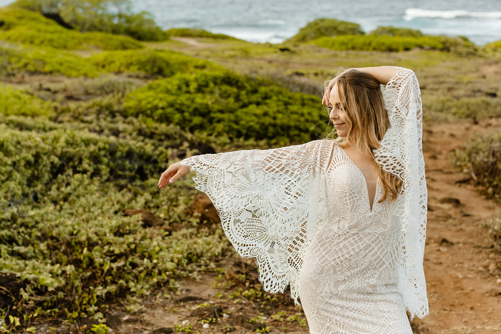 Bride poses in her wedding dress featuring wide wing sleeves.