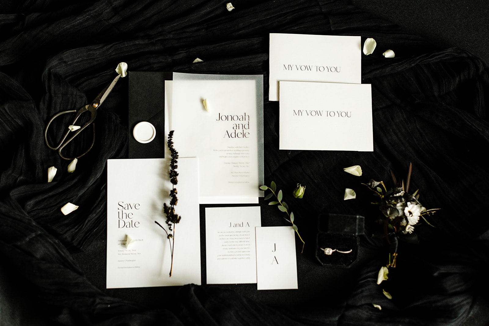 All black with white detailing flatlay of wedding invitations.