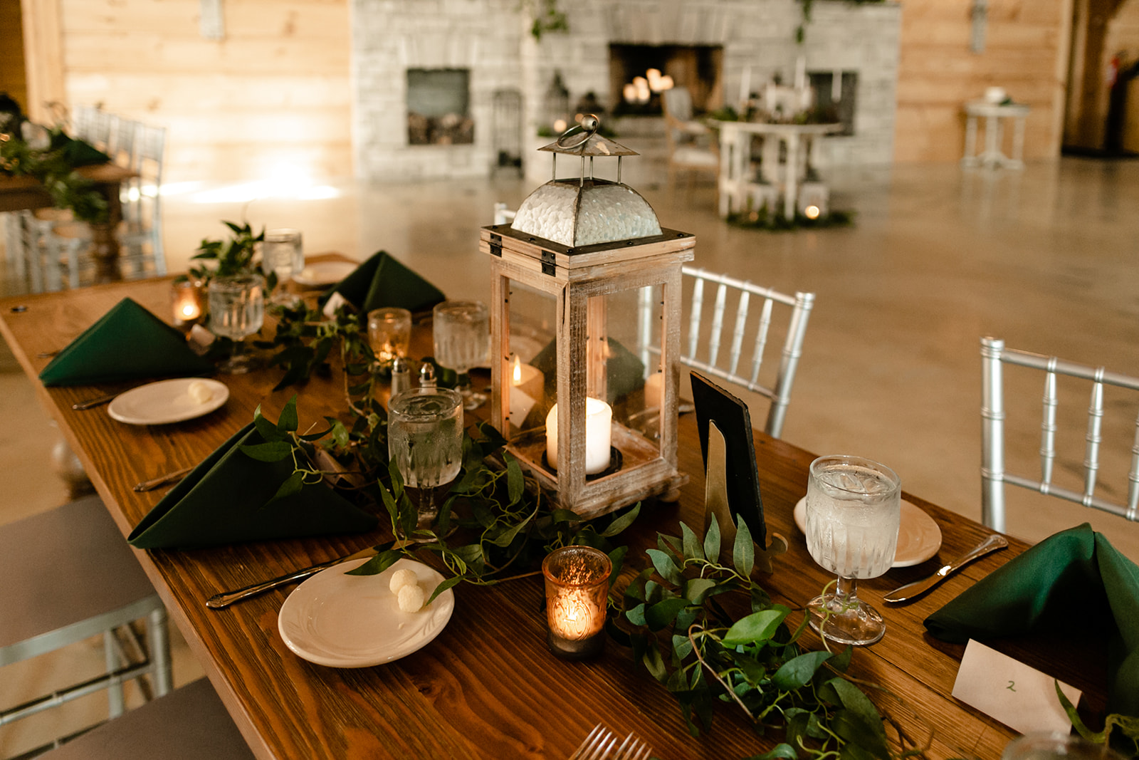 Close up on candles and lanterns and goblets at wedding reception.