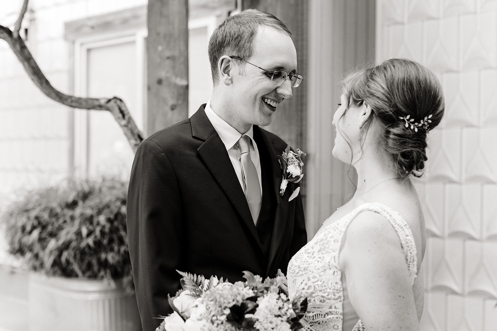 black and white. couple smiles at one another during first look before their seattle aquarium wedding.