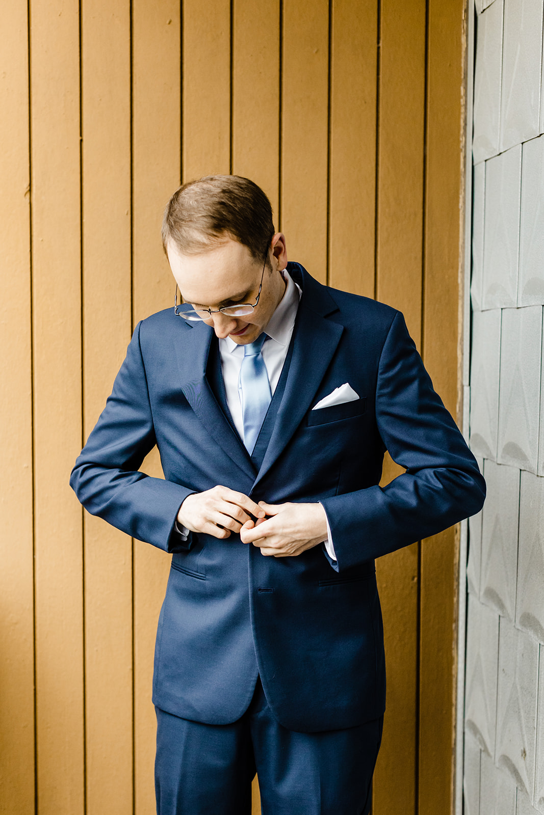 groom buttons his jacket