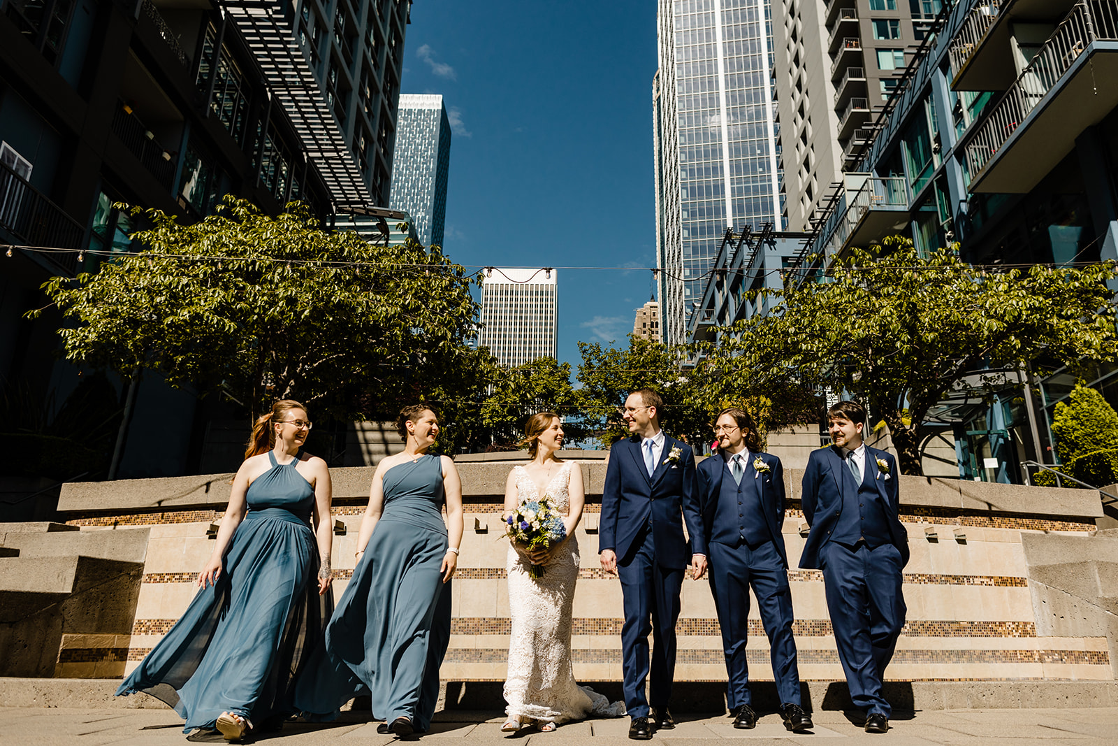 couple and wedding party walk toward the camera in downtown seattle.