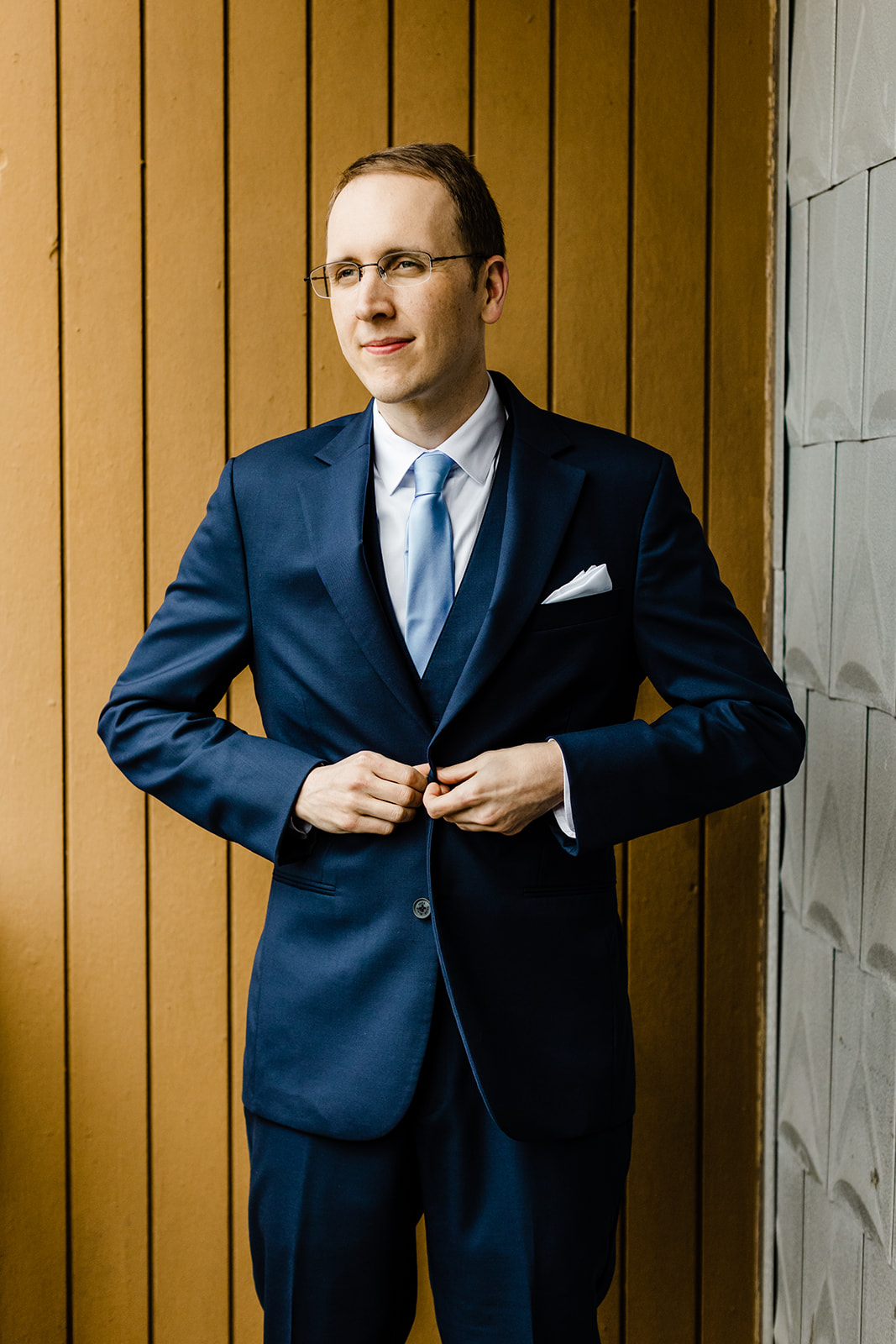 groom buttons his jacket