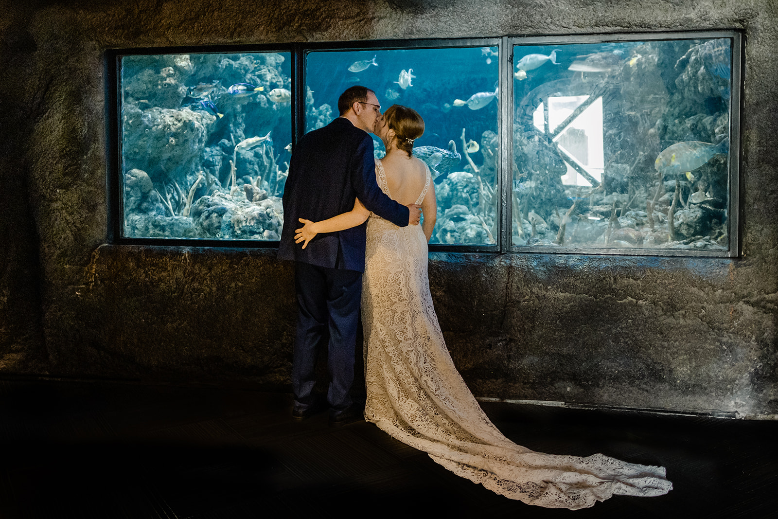 couple kisses at the seattle aquarium before their wedding ceremony.