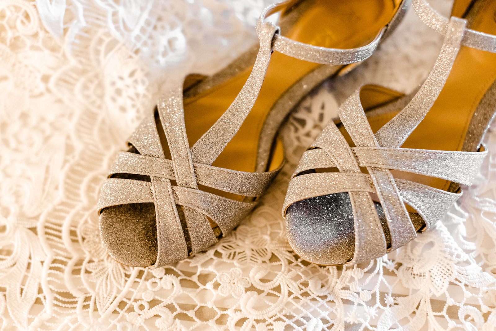bride's silver shoes rest on lace train