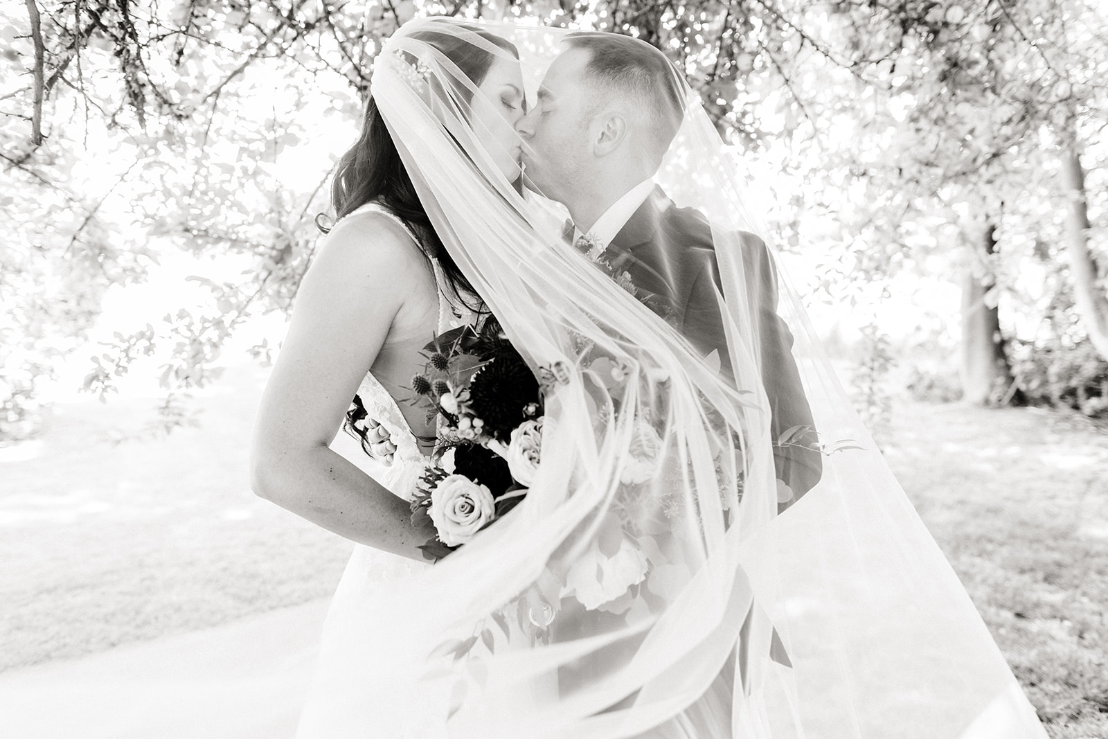 bride and groom portrait with veil over face