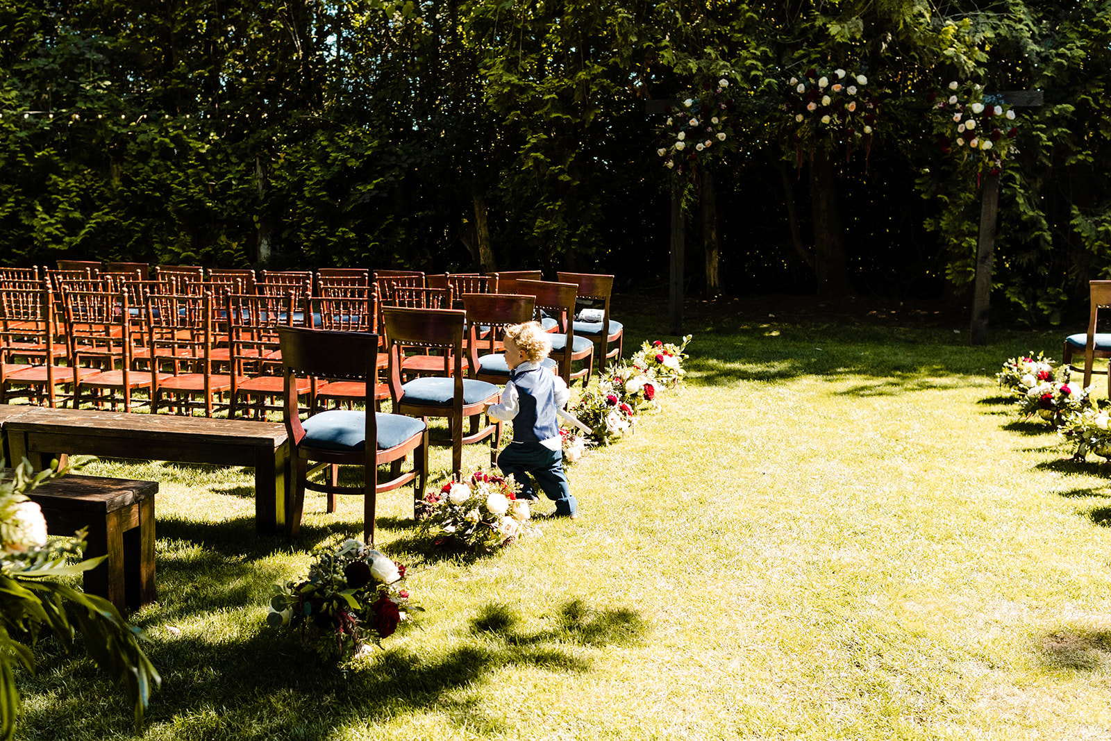 ring bearer runs through velvet ceremony chairs