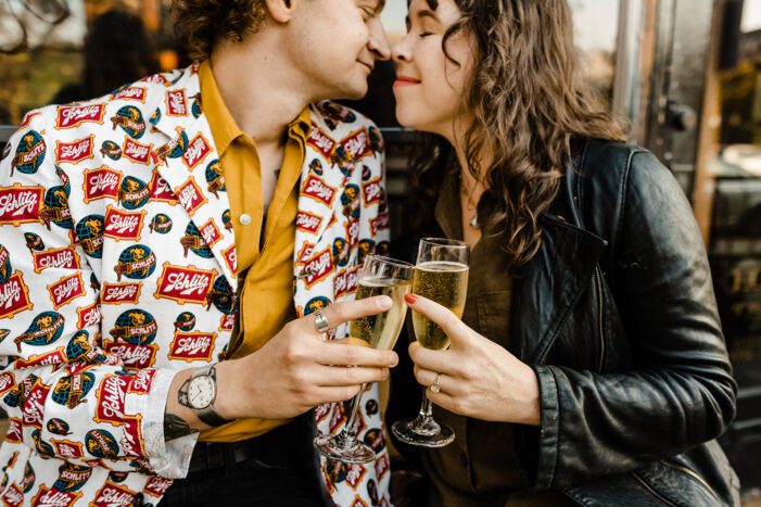 boy and girl almost kiss while holding champagne glasses