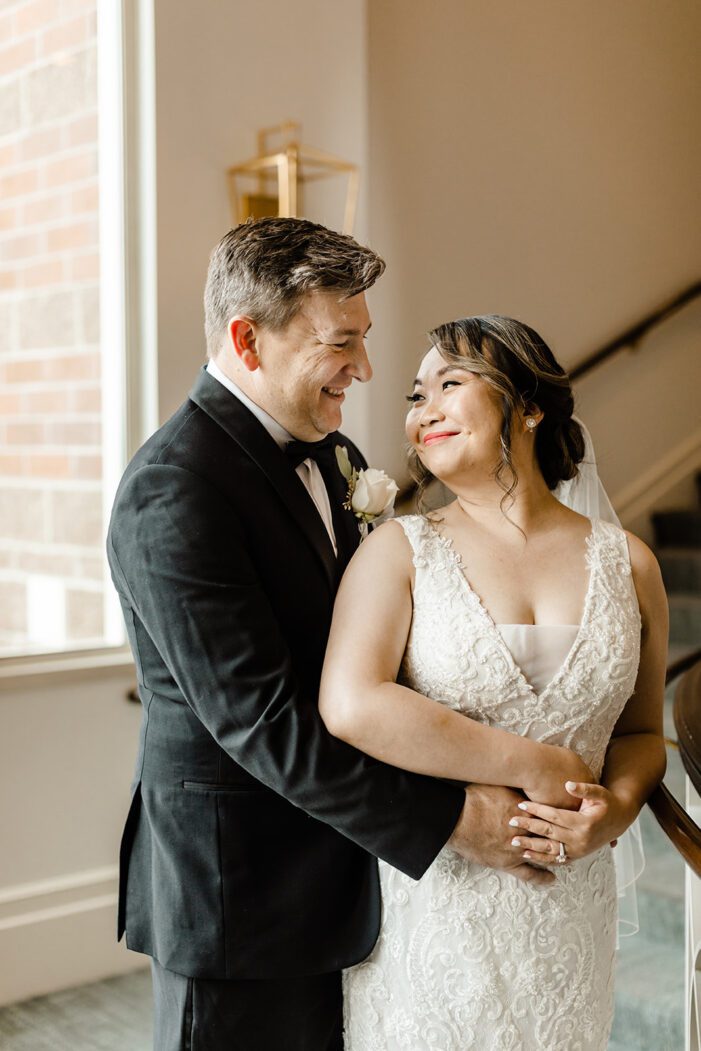 bride and groom look at each other while on staircase at woodmark hotel