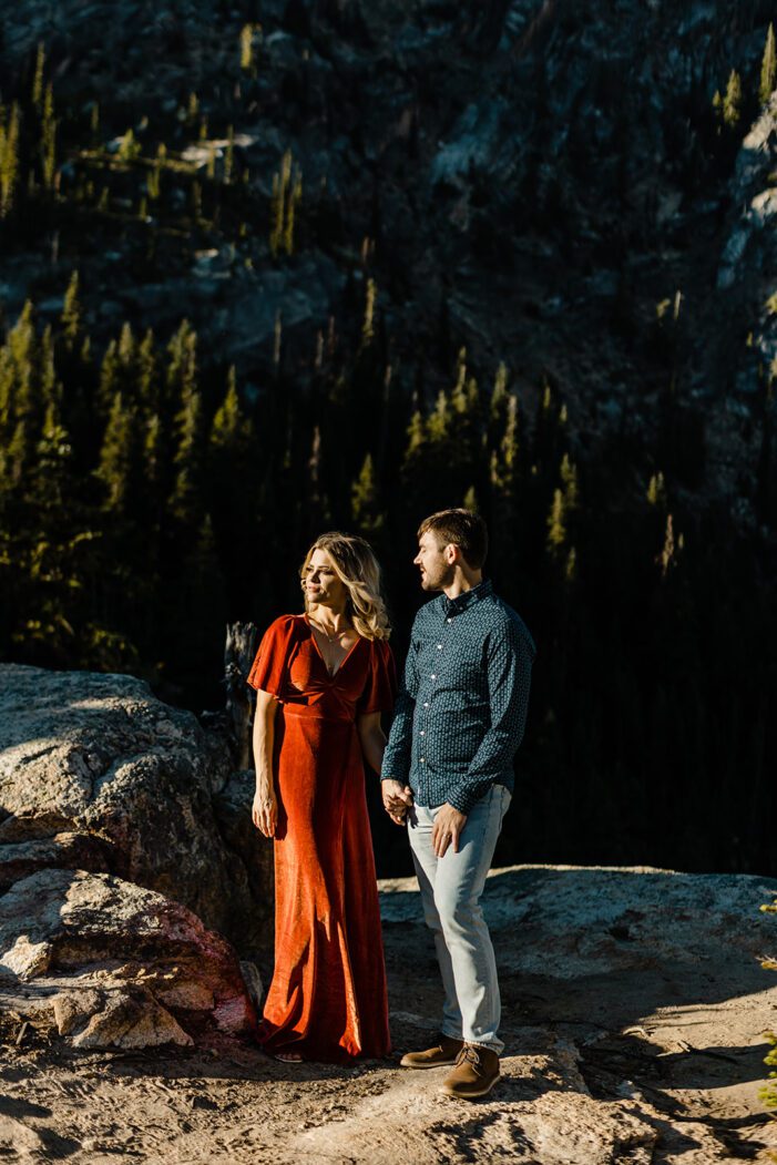 boy and girl face each other on cliffside in north cascades engagement photos