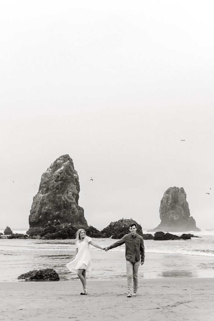 boy and girl hold hands and stand apart in front of ocean