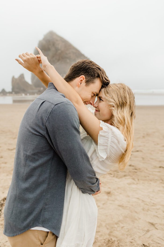 boy and girl hug on haystack rock