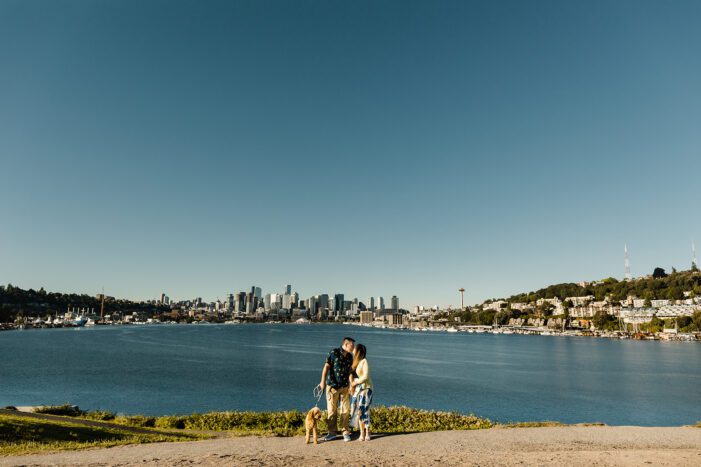 a couple poses near the water at gas works park