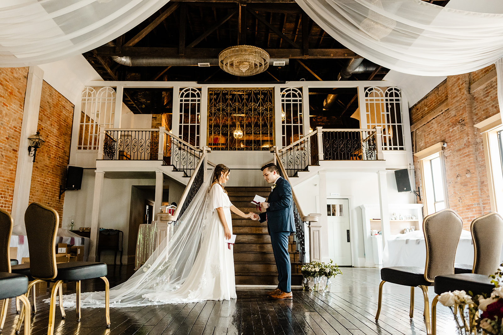 bride and groom stand in front of stairs