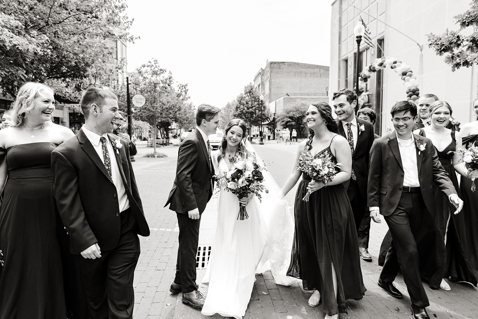 bride and groom walk with bridal party