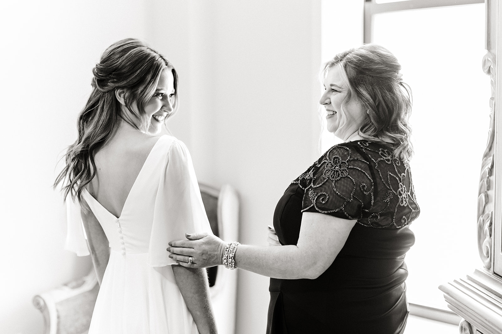bride and her mom smile at each other