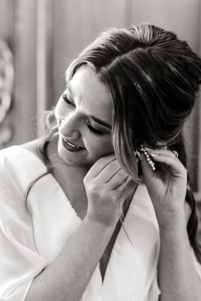 bride putting on earrings