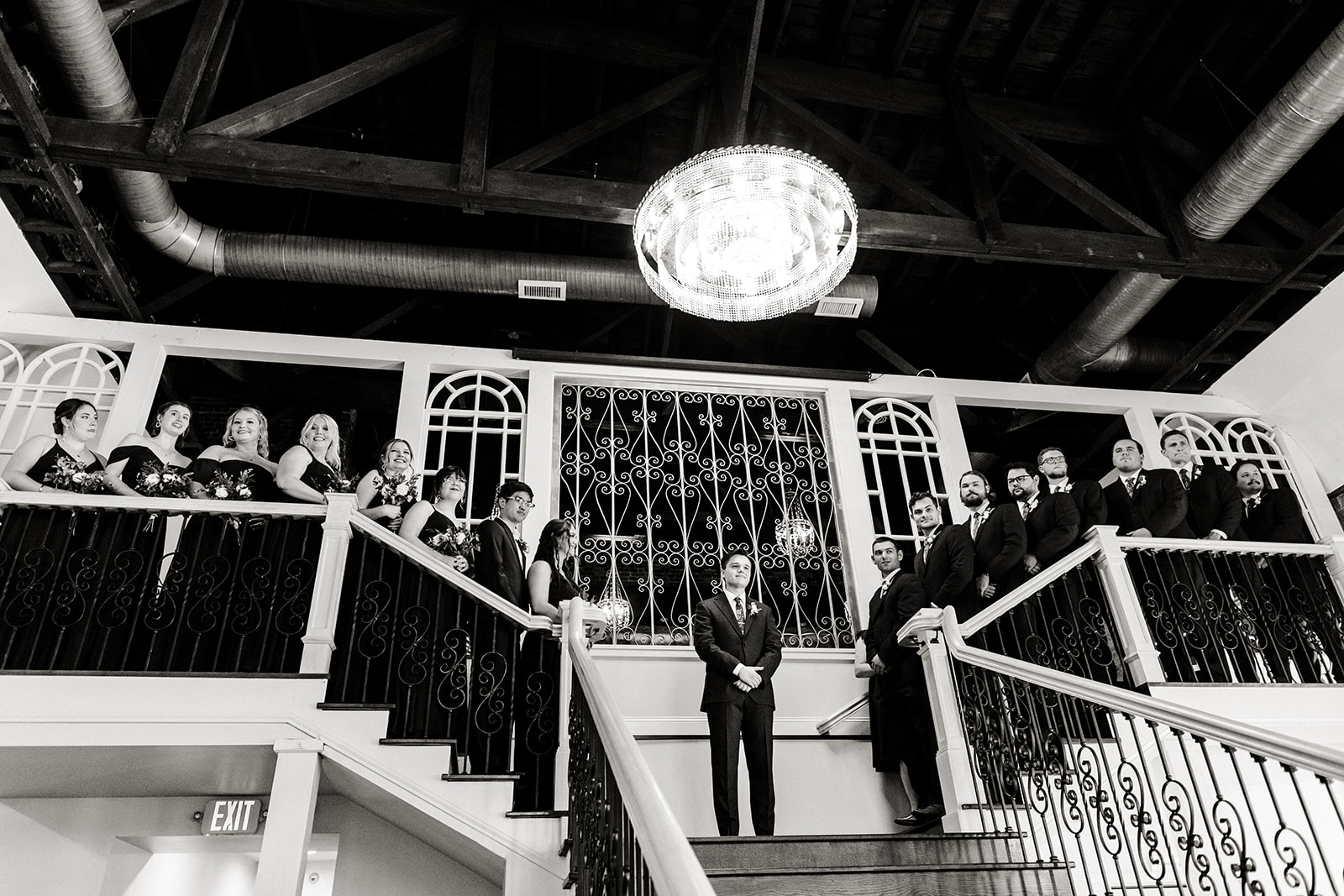 groom stands at the top of stairs during ceremony