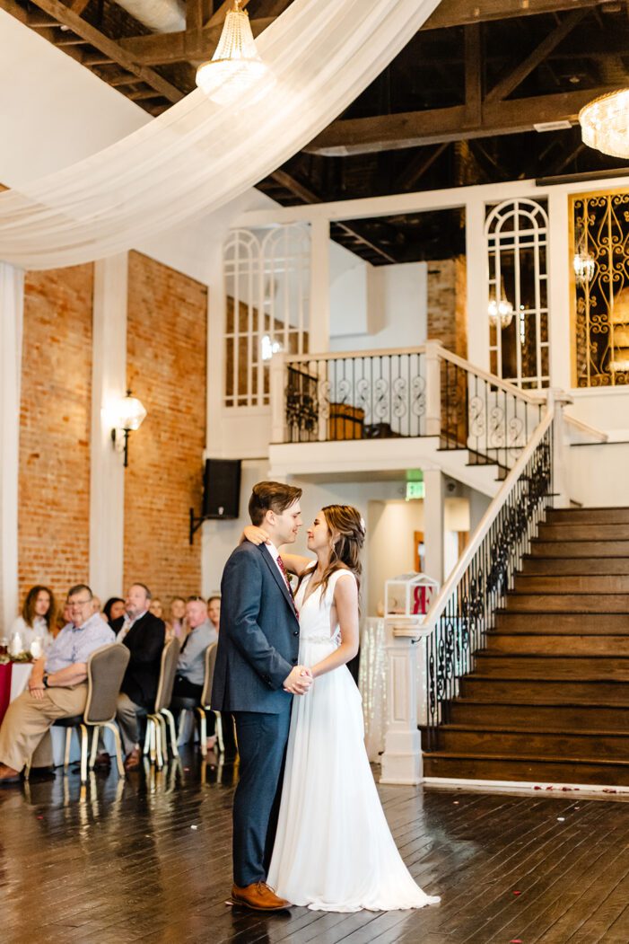 bride and groom share first dance in front of guests