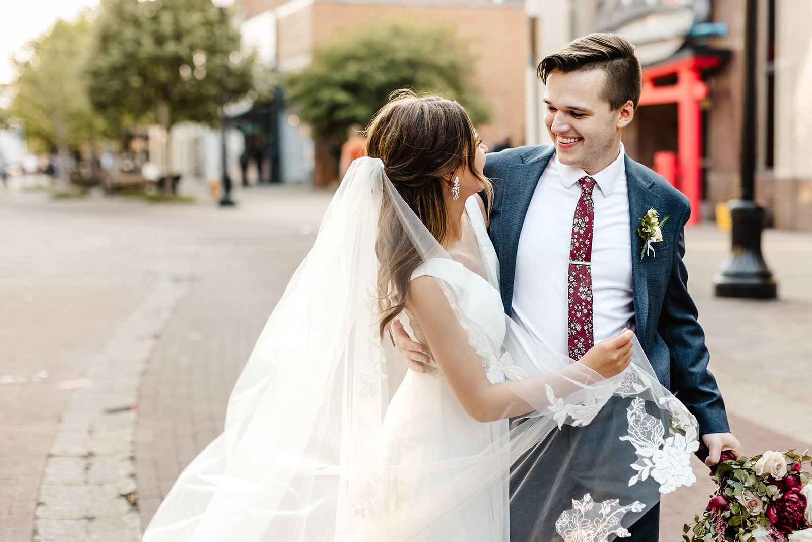 bride and groom bump hips as they walk together during classing wedding photography
