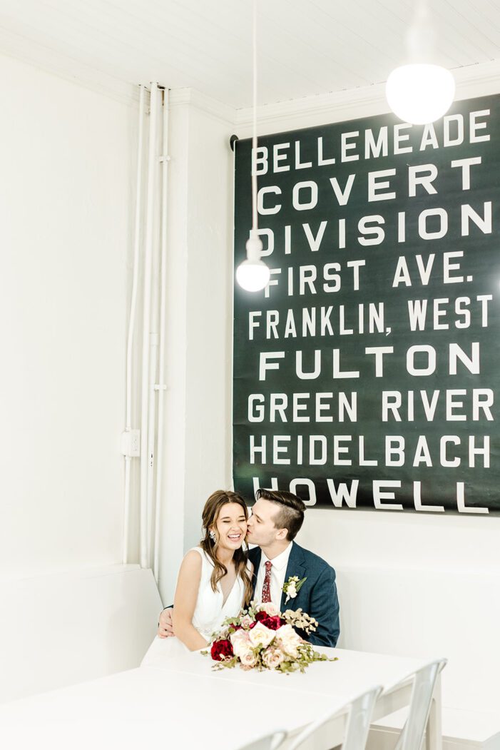 bride and groom snuggle in a coffee shop