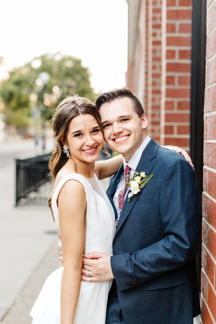 bride and groom walk down a bricked alley way together