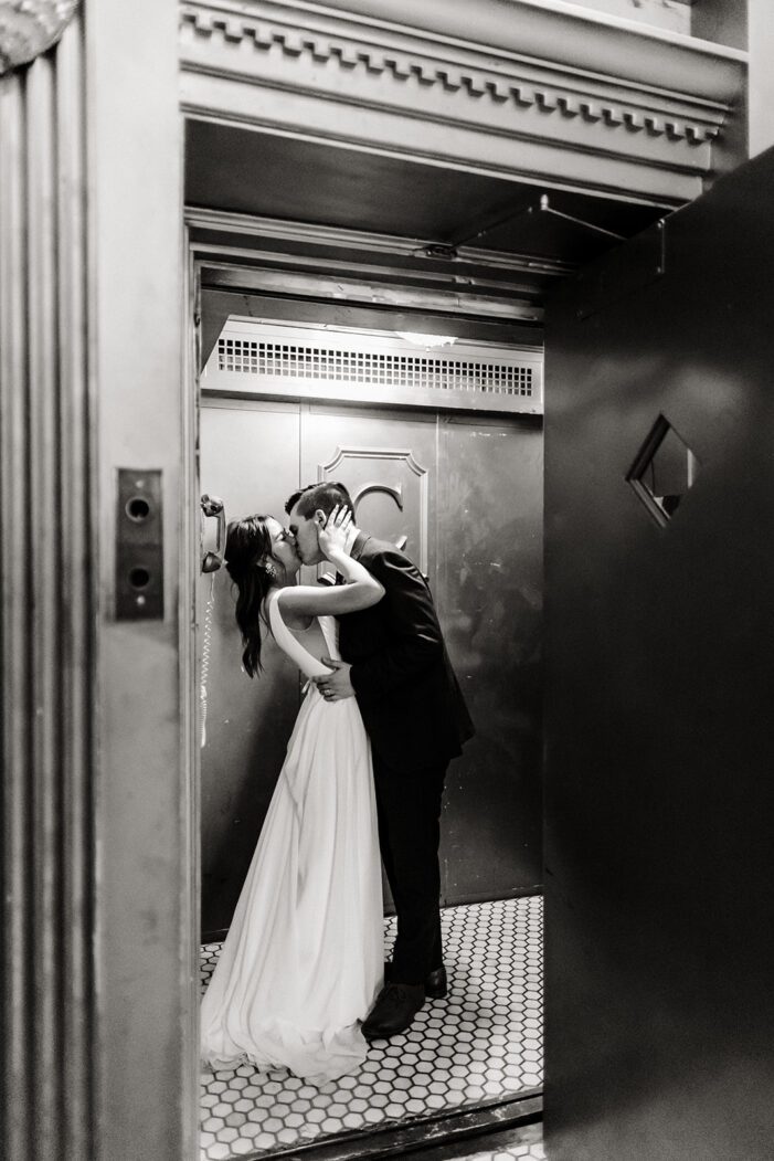 bride and groom kiss in a elevator