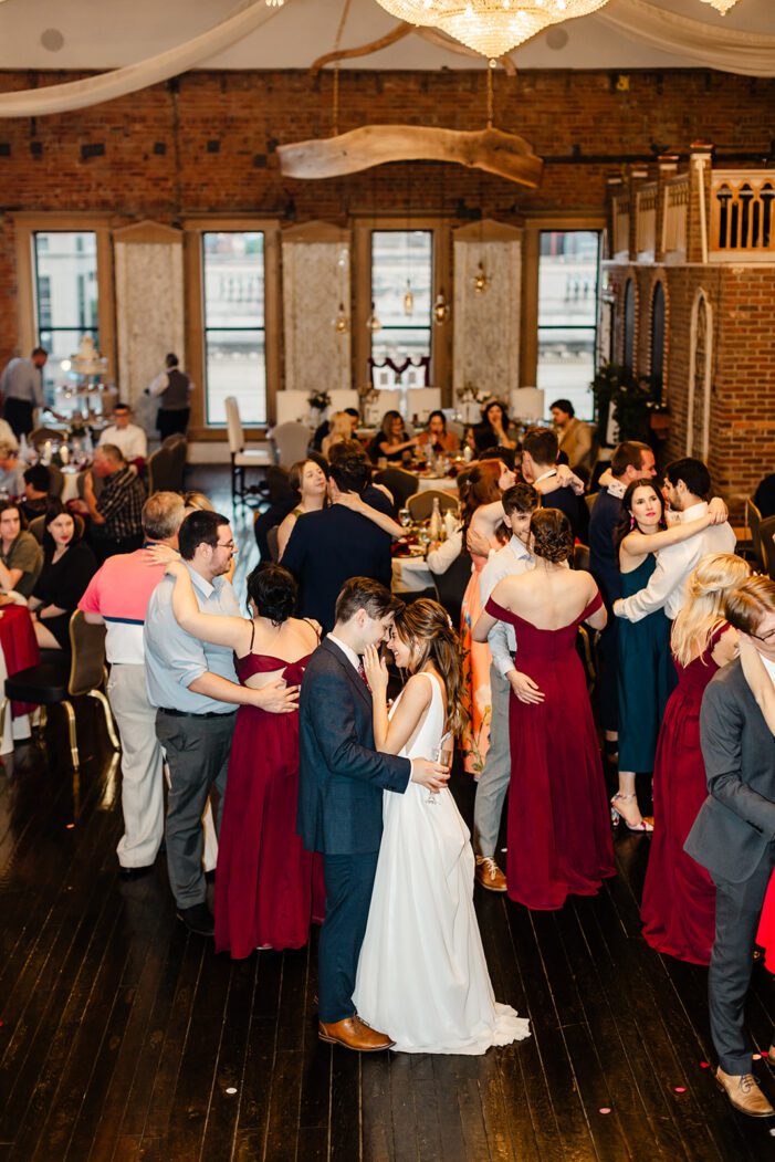 bride and groom slow dance among guests