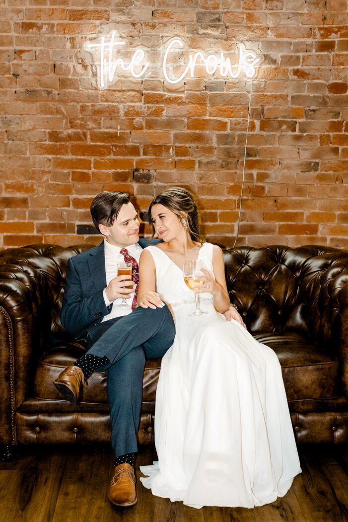 bride and groom cuddle on couch