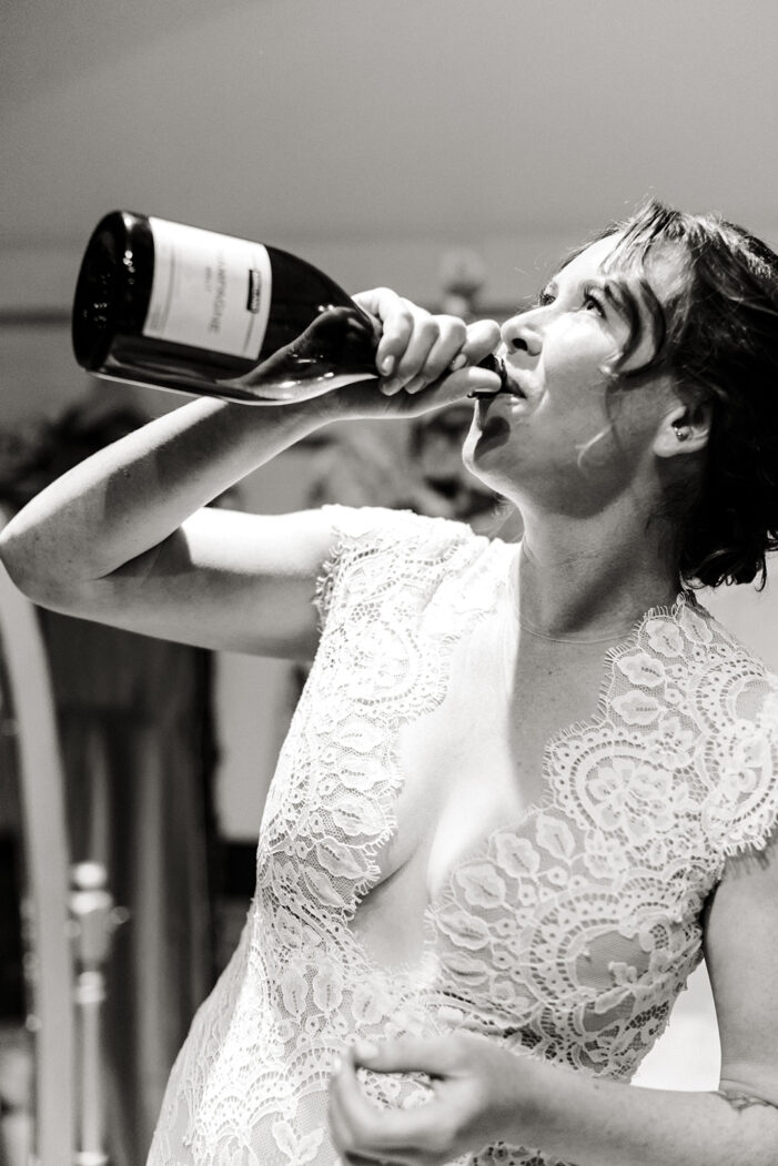 bride drinks from champagne bottle