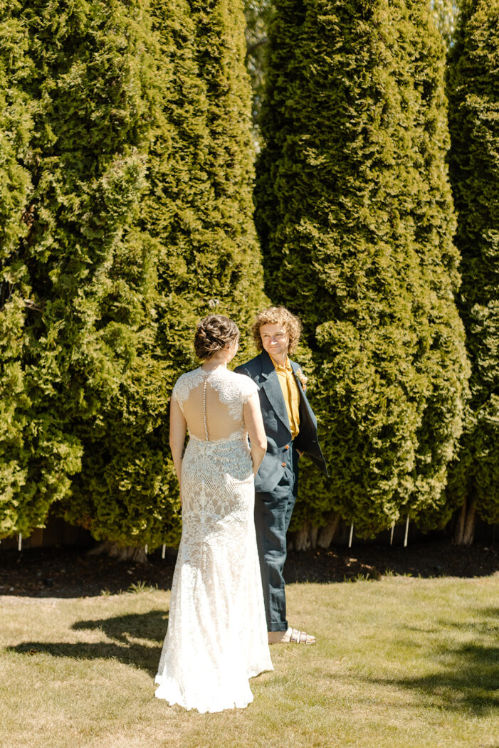 bride approaches groom from behind for first look