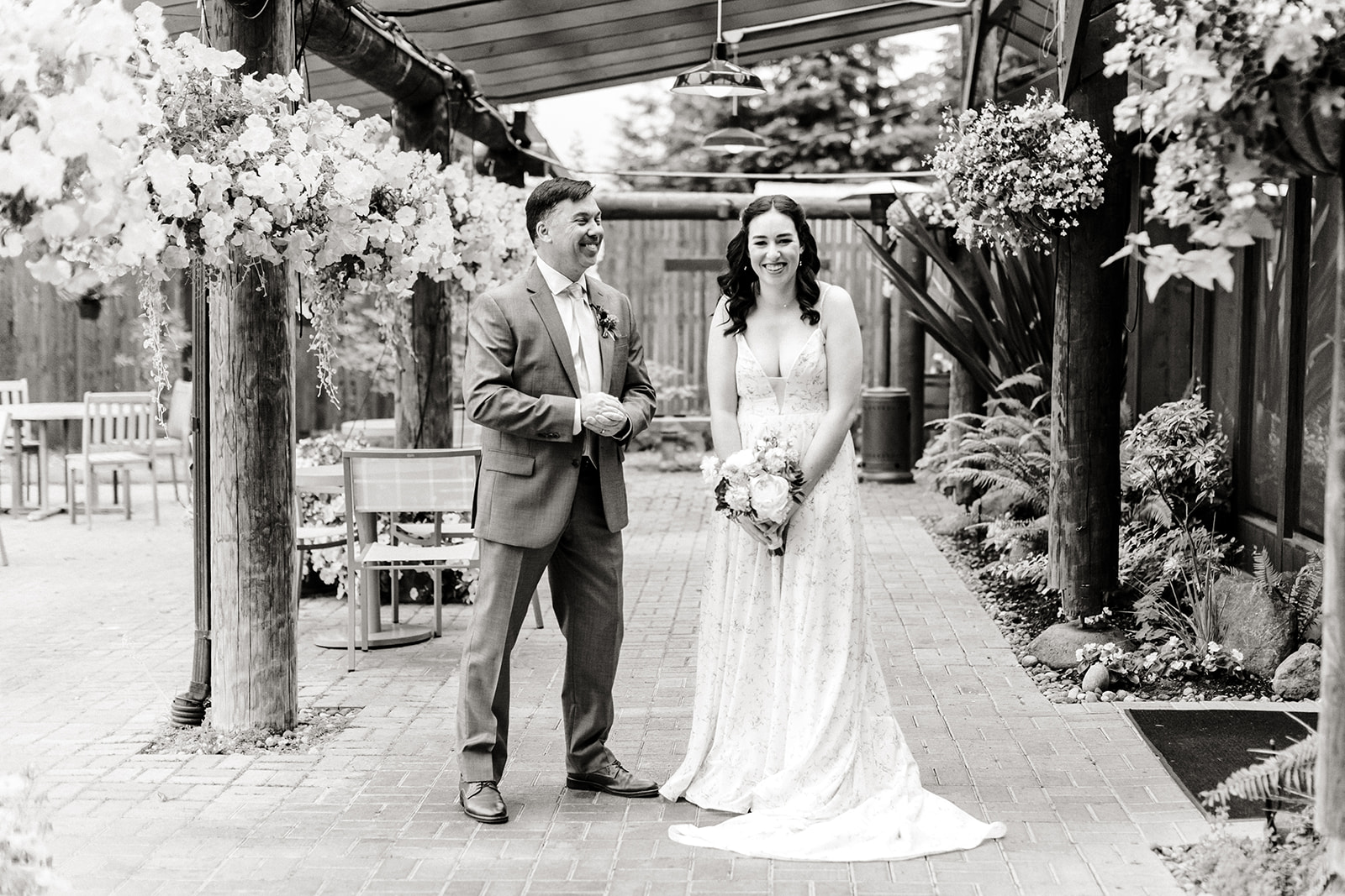 bride and older man stand together under archway
