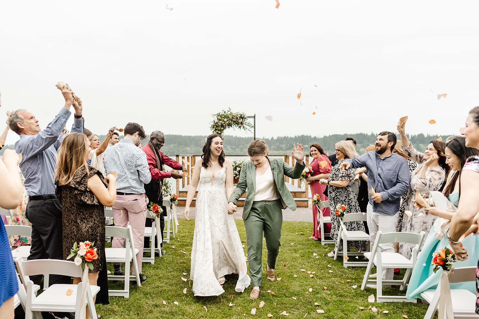 two brides walk up aisle amid cheers