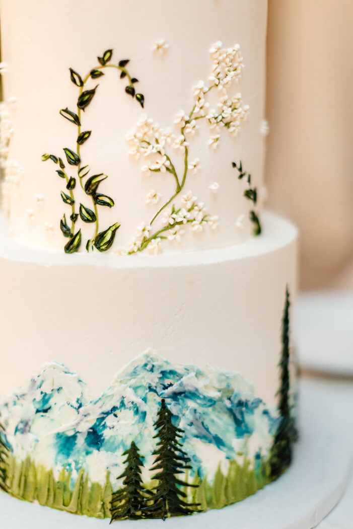 wedding cake with mountain painted onto it