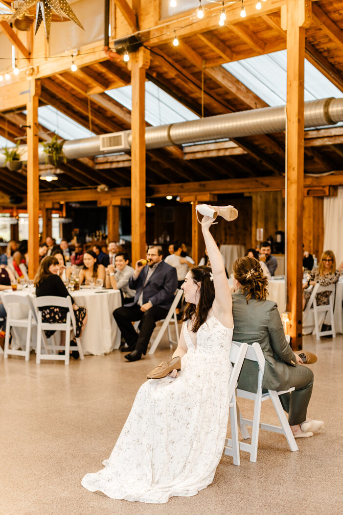 two brides play shoe game at wedding