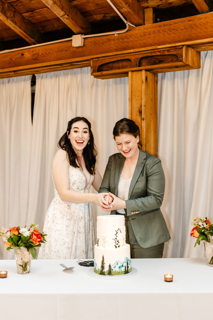 two brides cut cake at wedding
