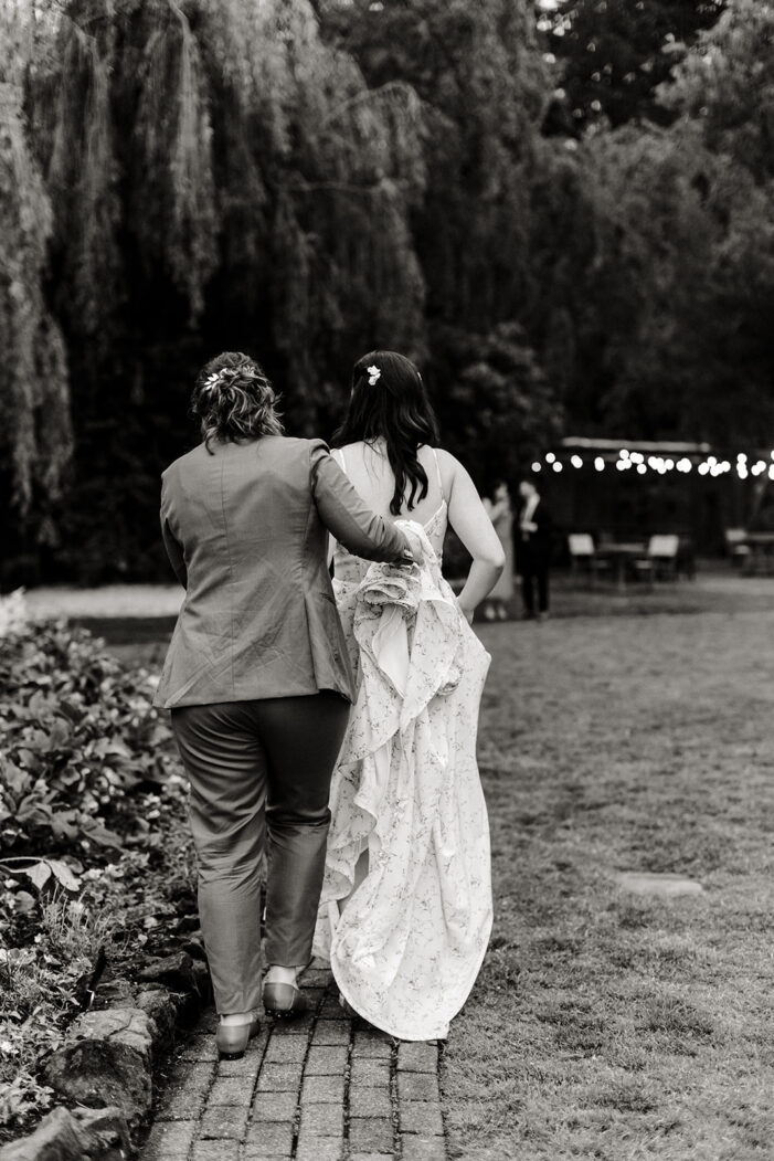 two brides walk across lawn