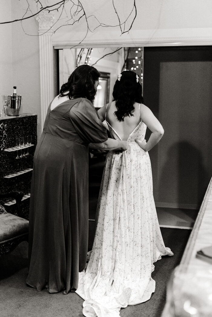woman helping a bride get dressed