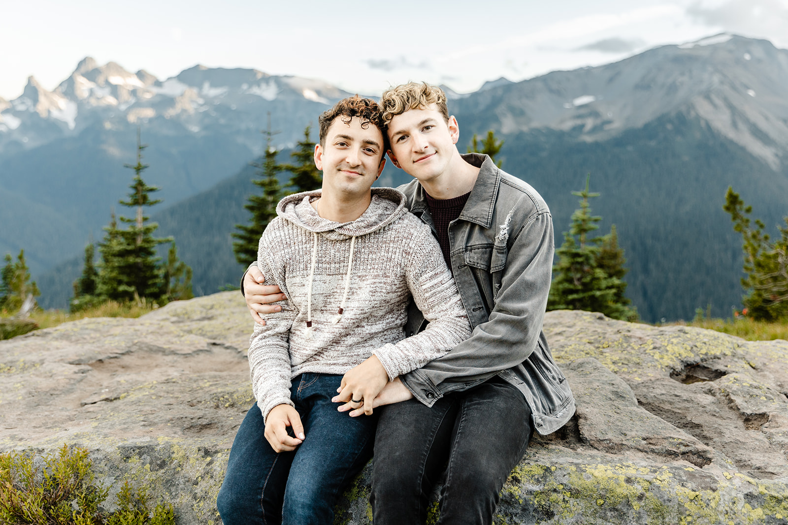 two boys sit on a rock together
