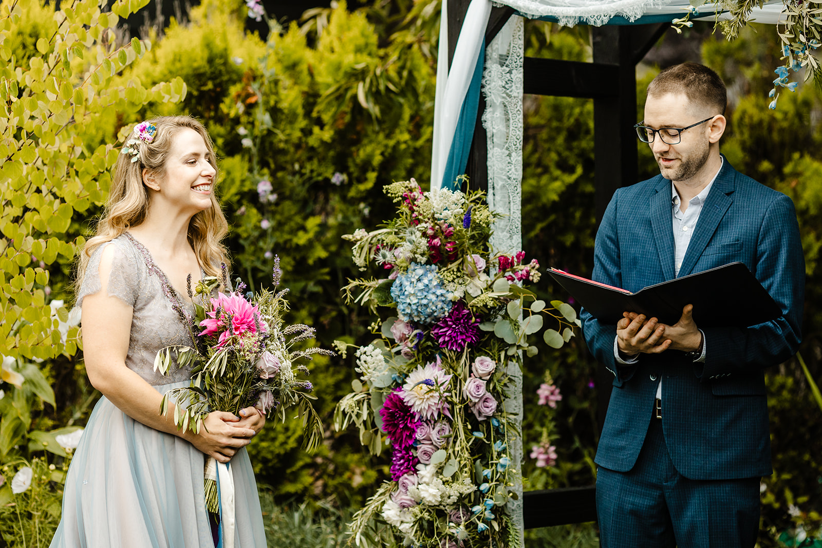 bride laughs during ceremony in backyard