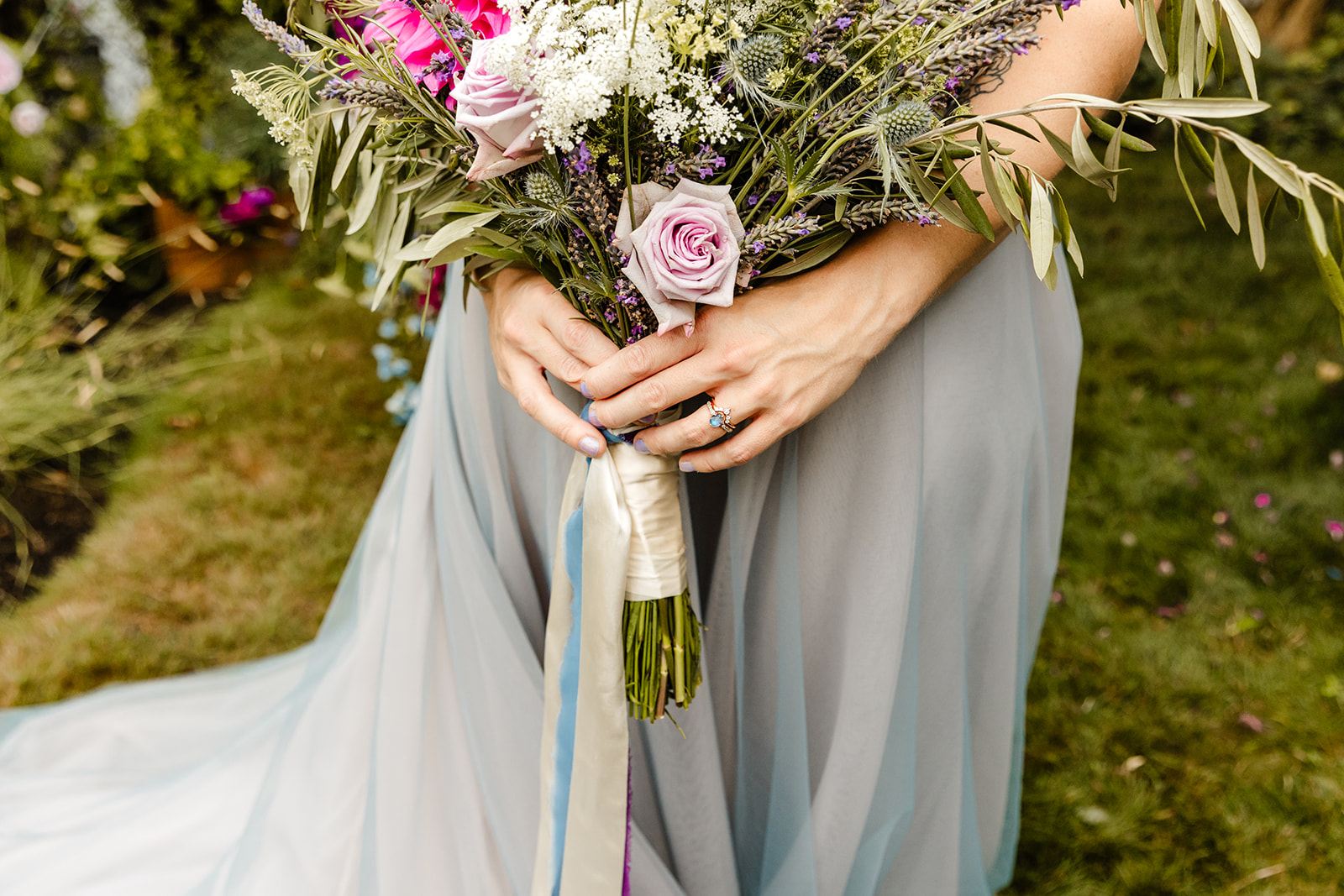 hands holding a bouquet with ribbons on it