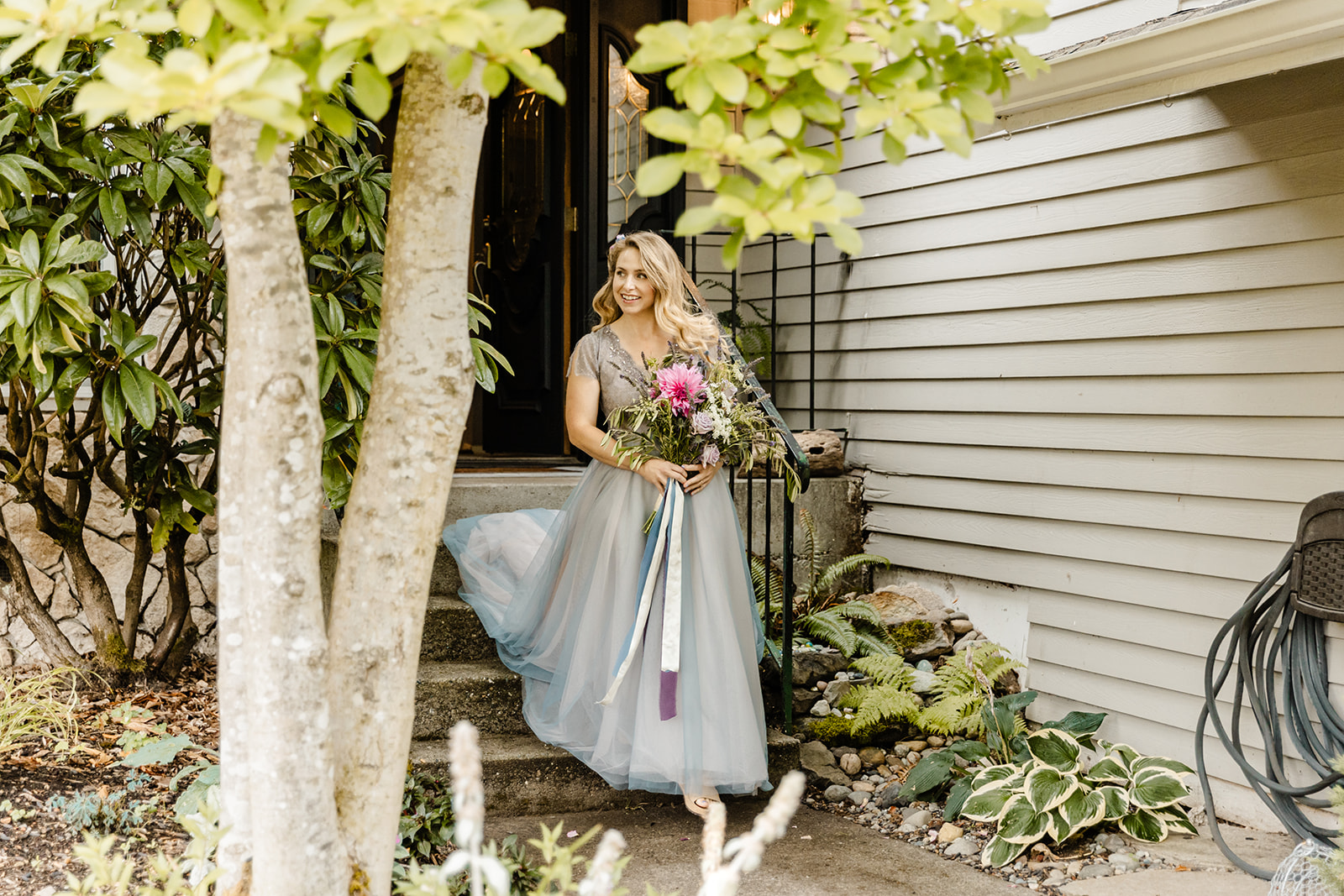bride walks out of house wearing blue dress